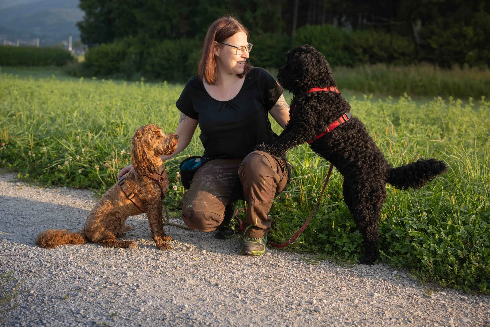 Tamara sitzt draußen mit ihren Hunden Shiva und Diego
